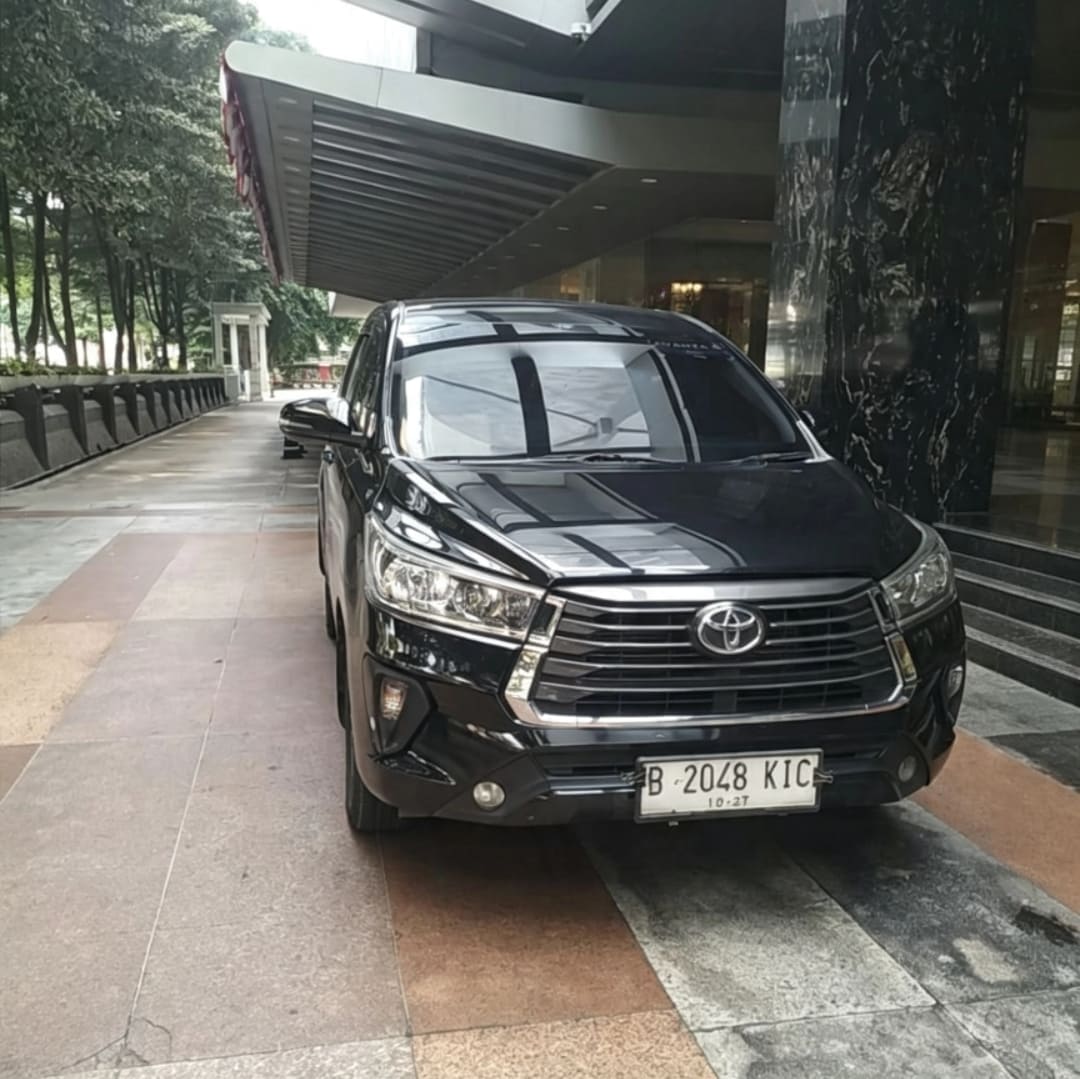 Toyota Innova Reborn silver SUV parked in front of modern building